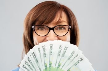 savings, finances and people concept - close up of smiling senior woman holding hundreds of euro money banknotes. senior woman with hundreds of euro money banknotes