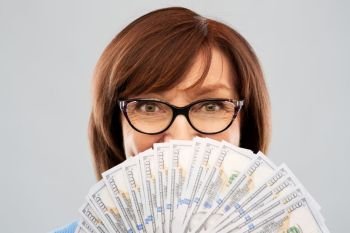 savings, finances and people concept - close up of senior woman holding hundreds of dollar money banknotes. senior woman with hundred dollar money banknotes
