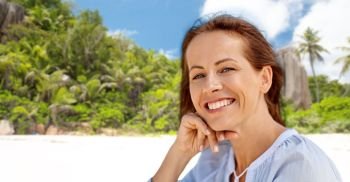 people and leisure concept - portrait of happy smiling woman over tropical beach on seychelles island background. portrait of happy smiling woman on summer beach