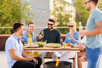 leisure and people concept - happy friends with non alcoholic drinks having bbq party on rooftop in summer. happy friends having bbq party on rooftop