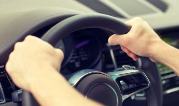 road trip, transport and people concept - close up of male hands driving car and holding wheel. close up of male hands driving car