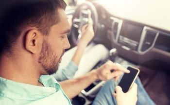leisure, road trip, travel, technology and people concept - happy man and woman with smartphones driving in car. man and woman with smartphones driving in car