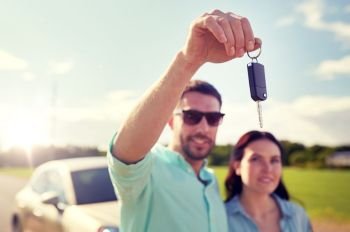 transport, road trip, travel, family and people concept - happy man and woman with car key outdoors. happy man and woman with car key outdoors