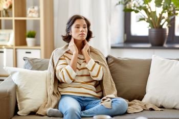 cold and health problem concept - sick woman touching her lymph nodes at home. sick woman touching her lymph nodes at home