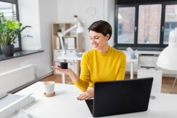 business, technology and internet of things concept - happy businesswoman using smart speaker at office. businesswoman using smart speaker at office