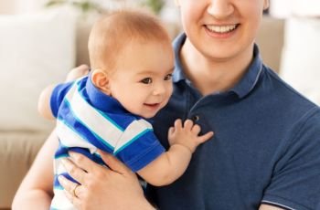 family, fatherhood and childhood concept - happy baby son with father at home. happy baby son with father at home