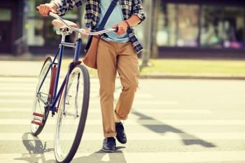 people, style, city life and lifestyle - young hipster man with shoulder bag and fixed gear bike and shoulder bag crossing crosswalk on street. young man with fixed gear bicycle on crosswalk