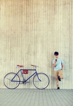 people, communication, technology, leisure and lifestyle - hipster man with smartphone and fixed gear bike on city street. man with smartphone and fixed gear bike on street