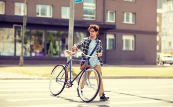 people, style, city life and lifestyle - young hipster man with shoulder bag and fixed gear bike crossing crosswalk on street. young man with fixed gear bicycle on crosswalk