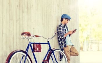 people, communication, technology and lifestyle - hipster man with smartphone, earphones and fixed gear bike listening to music on city street. man with smartphone, earphones and bicycle