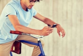 people, communication, technology, leisure and lifestyle - hipster man texting on smartphone with fixed gear bike on street. man with smartphone and fixed gear bike on street
