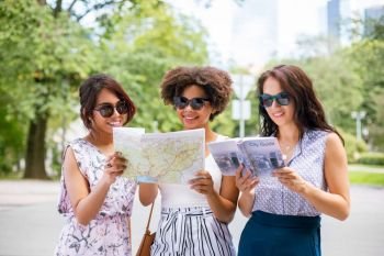 tourism, travel and friendship concept - happy tourist women or friends with map and city guide on street in summer. women with map and city guide on street in summer