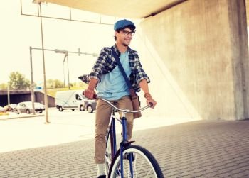 people, style, leisure and lifestyle - young hipster man with shoulder bag riding fixed gear bike on city street. young hipster man with bag riding fixed gear bike