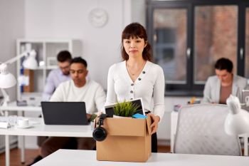 business, firing and job loss concept - sad fired asian female office worker with box of her personal stuff. female office worker with box of personal stuff