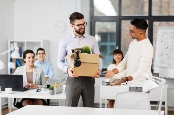 business, new job and corporate concept - male office worker with box of personal stuff and happy smiling colleague introducing workplace. new male employee meeting colleagues at office