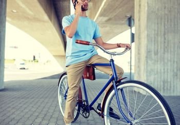 people, communication, technology, leisure and lifestyle - hipster man with fixed gear bike calling on smartphone on street. man with smartphone and fixed gear bike on street