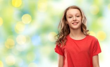 people concept - smiling teenage girl with long hair in red t-shirt over summer green lights background. teenage girl in red t-shirt over green lights