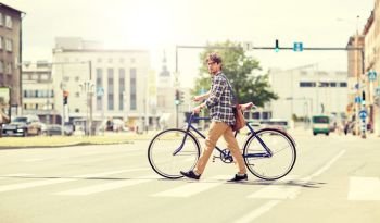 people, style, city life and lifestyle - young hipster man with shoulder bag and fixed gear bike crossing crosswalk on street. young man with fixed gear bicycle on crosswalk