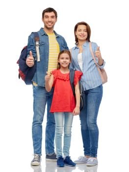 family, tourism and travel concept - happy smiling mother, father and little daughter with backpacks showing thumbs up over white background. happy family with travel bags showing thumbs up