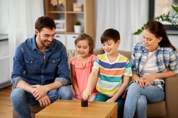 family, technology and internet of things concept - happy father, mother, little son and daughter with smart speaker at home. happy family with smart speaker at home