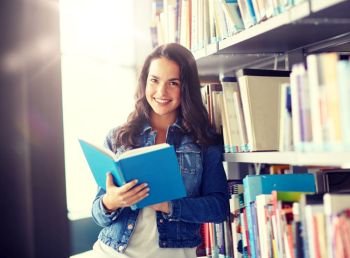 education, high school, university, learning and people concept - smiling student girl reading book at library. high school student girl reading book at library