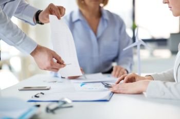 business, corporate and people concept - businessman showing financial report to businesswoman at office. business team with financial report at office
