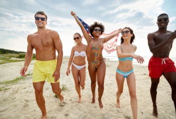 independence day, summer holidays and people concept - group of happy friends with american flag on beach celebrating 4th of july. happy friends with american flag on summer beach