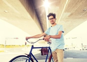 people, style, leisure and lifestyle - hipster man with fixed gear bike under city bridge. hipster man with fixed gear bike under bridge