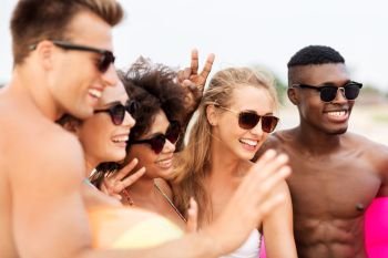 friendship, summer holidays and people concept - happy smiling friends in sunglasses on beach. happy friends in sunglasses on summer beach