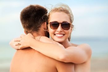 love, summer holidays and people concept - happy couple hugging on beach. happy couple hugging on summer beach