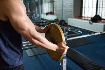 sport equipment, bodybuilding and people concept - close up of man or bodybuilder with barbell weight in gym. close up of man with barbell weight in gym