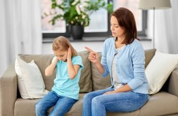 misbehavior, conflict and family concept - angry mother scolding her daughter at home. angry mother scolding her daughter at home