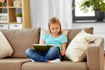 people, childhood and leisure concept - little girl reading book at home. little girl reading book at home