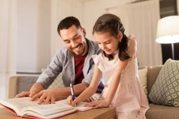 education, family and homework concept - happy father and daughter with book writing to notebook at home. father and daughter doing homework together