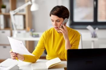 business, startup and people concept - happy businesswoman with papers calling on smartphone at office. businesswoman calling on smartphone at office