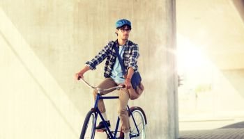 people, style, leisure and lifestyle - young hipster man with shoulder bag riding fixed gear bike on city street. young hipster man with bag riding fixed gear bike