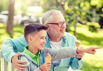 family, generation, communication and people concept - happy grandfather and grandson eating ice cream at summer park. old man and boy eating ice cream at summer park