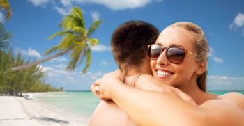 summer holidays, vacation and travel concept - happy couple hugging over tropical beach background in french polynesia. happy couple hugging on summer beach