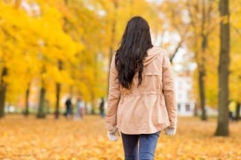season and people concept - young woman walking in autumn park. young woman walking in autumn park