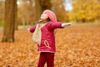 childhood, season and people concept - happy girl at autumn park. happy girl at autumn park