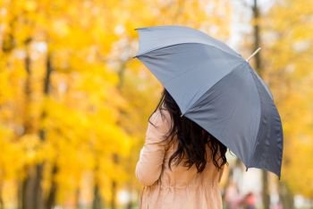 season, rainy weather and people concept - young woman with umbrella in autumn park. young woman with umbrella in autumn park