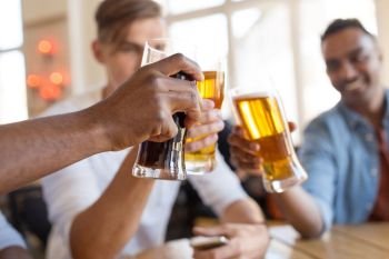 drinks, leisure and celebration concept - happy male friends drinking beer and clinking glasses at bar or pub. happy male friends drinking beer at bar or pub