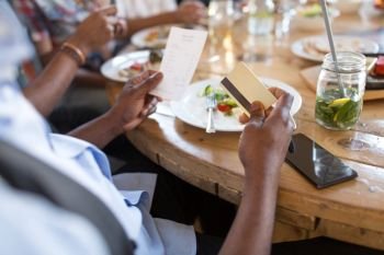 leisure, food and payment concept - male hands holding bill and credit card at restaurant. hands holding bill and credit card at restaurant