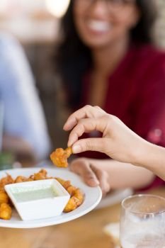 food and eating concept - close up of hand with snack and dip sauce at restaurant. hand with snack and dip sauce at restaurant