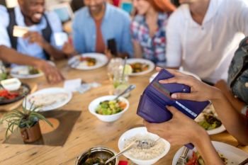 leisure, food and payment concept - female hands holding wallet at restaurant. female hands holding wallet at restaurant