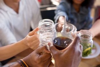 leisure, food and people concept - group of happy international friends clinking glasses at bar or restaurant. friends clinking glasses at bar or restaurant