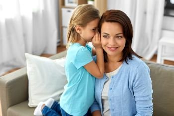 trust, gossiping and family concept - daughter whispering secret to mother at home. daughter whispering secret to mother at home