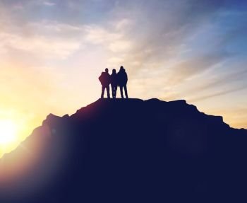 travel, tourism and hike concept - group of travelers with backpacks on mountain top over sunrise background. group of travelers with backpacks over sunrise