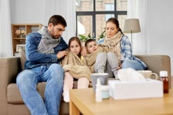 family, health and people concept - sick father, mother and ill children having flu at home. sick family with children having flu at home