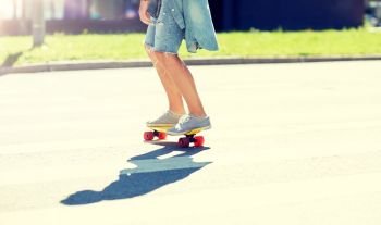 summer, extreme sport and people concept - teenage boy riding short modern cruiser skateboard on crosswalk in city. teenage boy on skateboard crossing city crosswalk